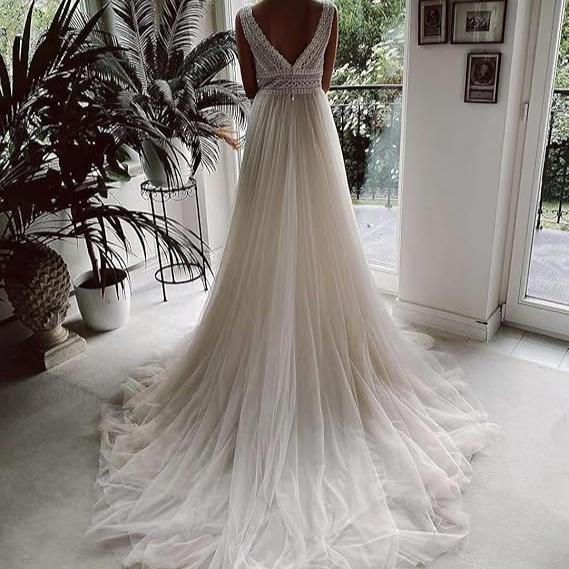 Robe de mariée bohème luxe en dentelle, style bohème avec détails floraux, portée par une mariée pour un mariage élégant.