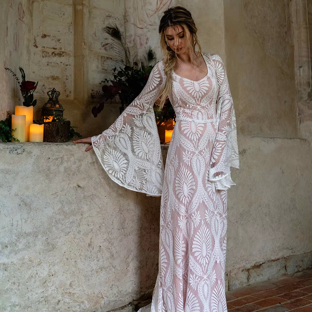 Robe de mariée bohème rose poudrée avec dentelle délicate, en tissu fluide et élégant, idéale pour un mariage romantique.