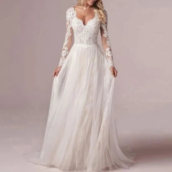 Robe de mariée bohème chic avec dentelle et décolleté en V, portée par un mannequin dans une ambiance romantique.