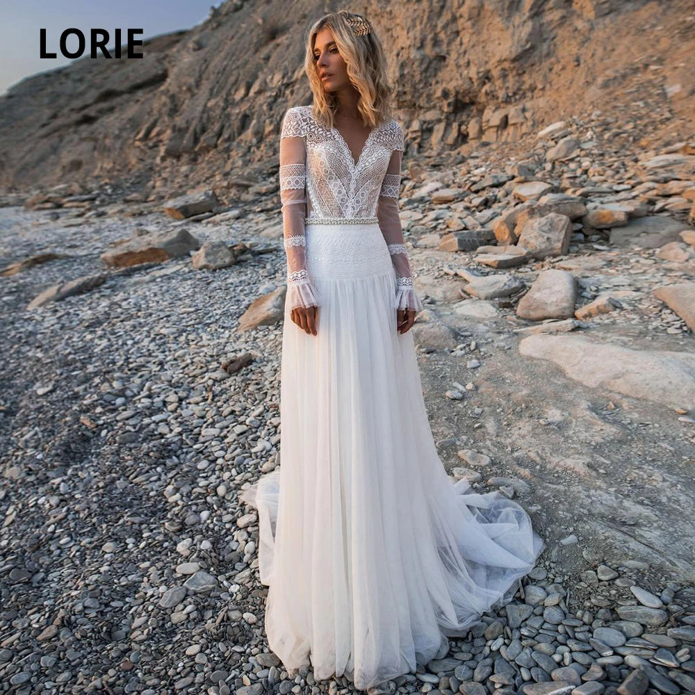 Robe de mariée bohème chic à manches longues, dentelle délicate et jupe fluide pour mariage romantique.