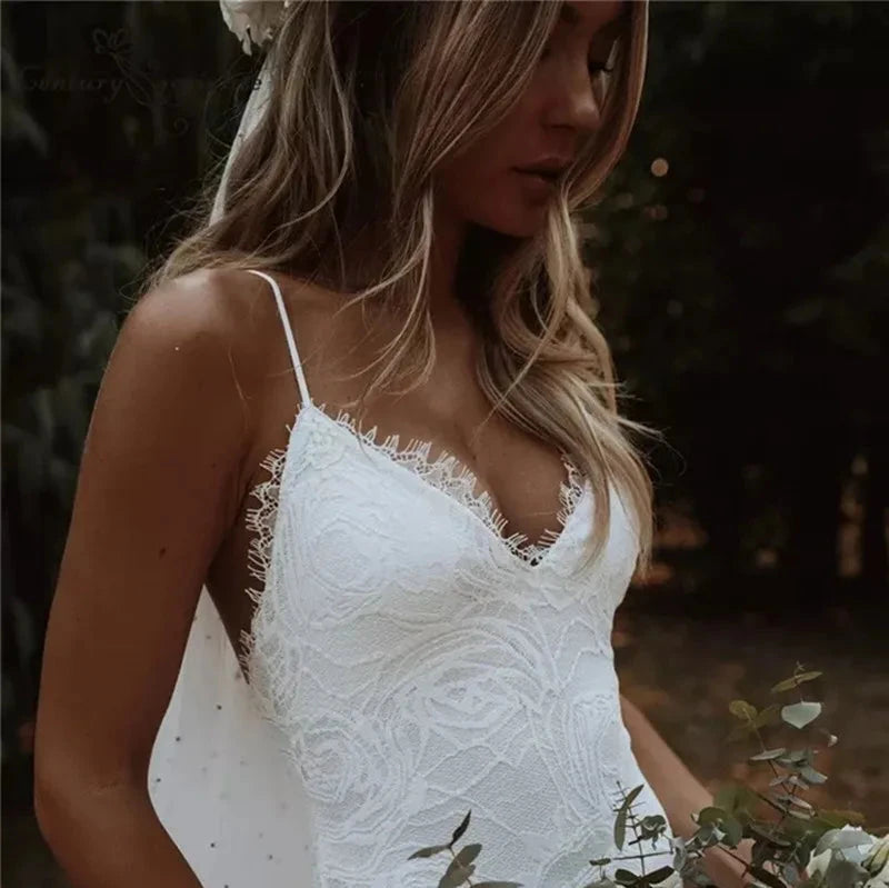 Robe de mariée bohème moderne en dentelle blanche avec décolleté en V et manches longues, portée par une mariée élégante.