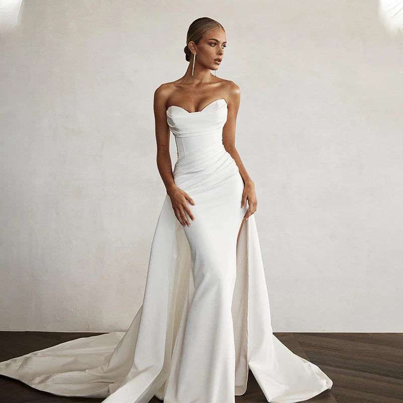 Robe de mariée sirène avec traîne de la marque Robe de mariée Paris, en tissu blanc élégant et ajusté.