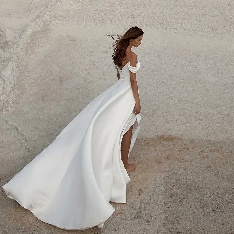 Robe de mariée asymétrique de Robe de mariée Paris, détail de la coupe élégante et tissu fluide sur fond blanc.