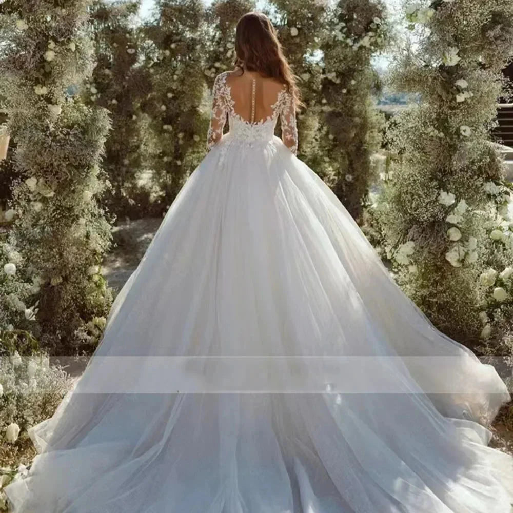 Robe de mariée bohème princesse en dentelle blanche avec décolleté en V et jupe fluide, portée par une mannequin lors d’un défilé.