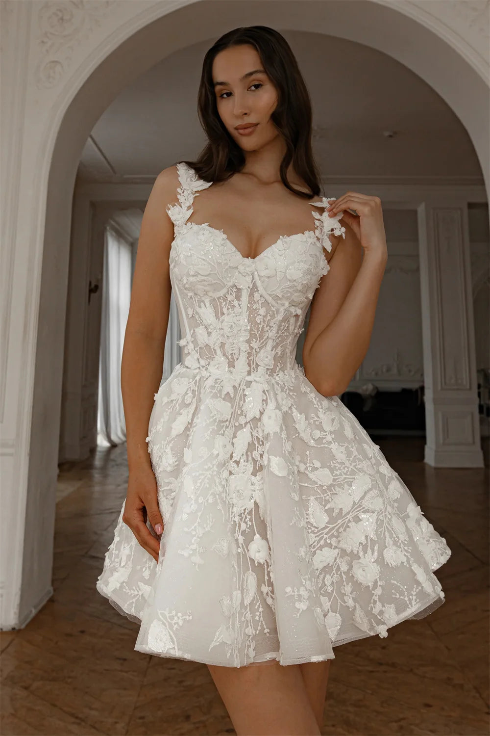 Robe de mariée courte et originale de la marque Robe de mariée Paris, en tissu blanc avec détails élégants.