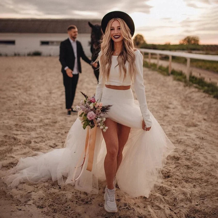Robe de mariée bohème Rock avec dentelle, manches longues et silhouette fluide, portée lors d'un mariage en plein air.