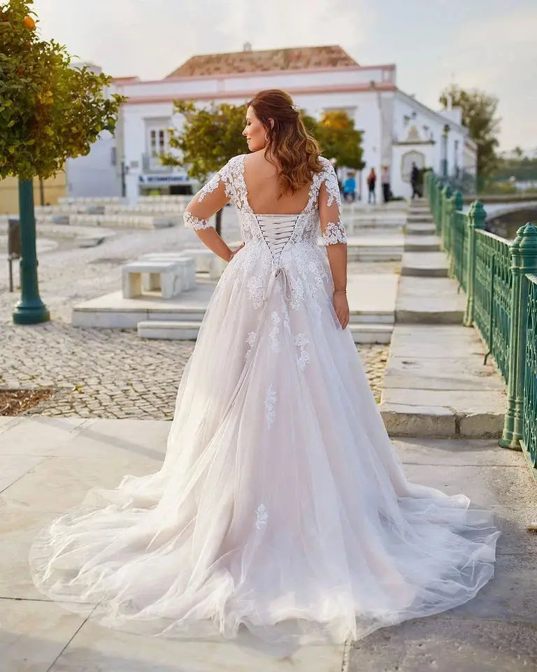Robe de mariée pour femme forte de la marque Robe de mariée Paris, robe longue en dentelle avec décolleté en V.