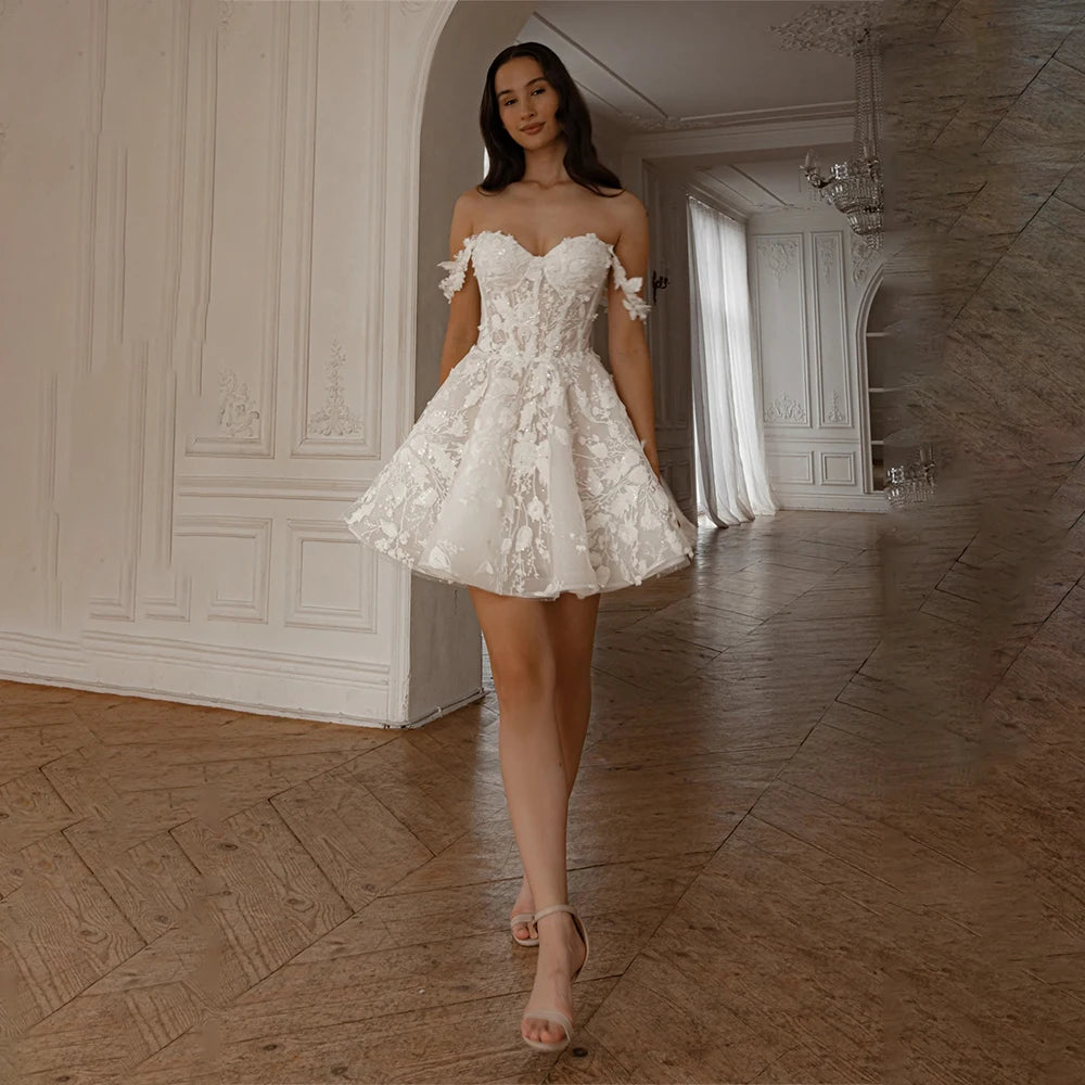 Robe de mariée originale courte de la marque Robe de Mariée Paris, détail en tissu blanc avec broderies délicates.