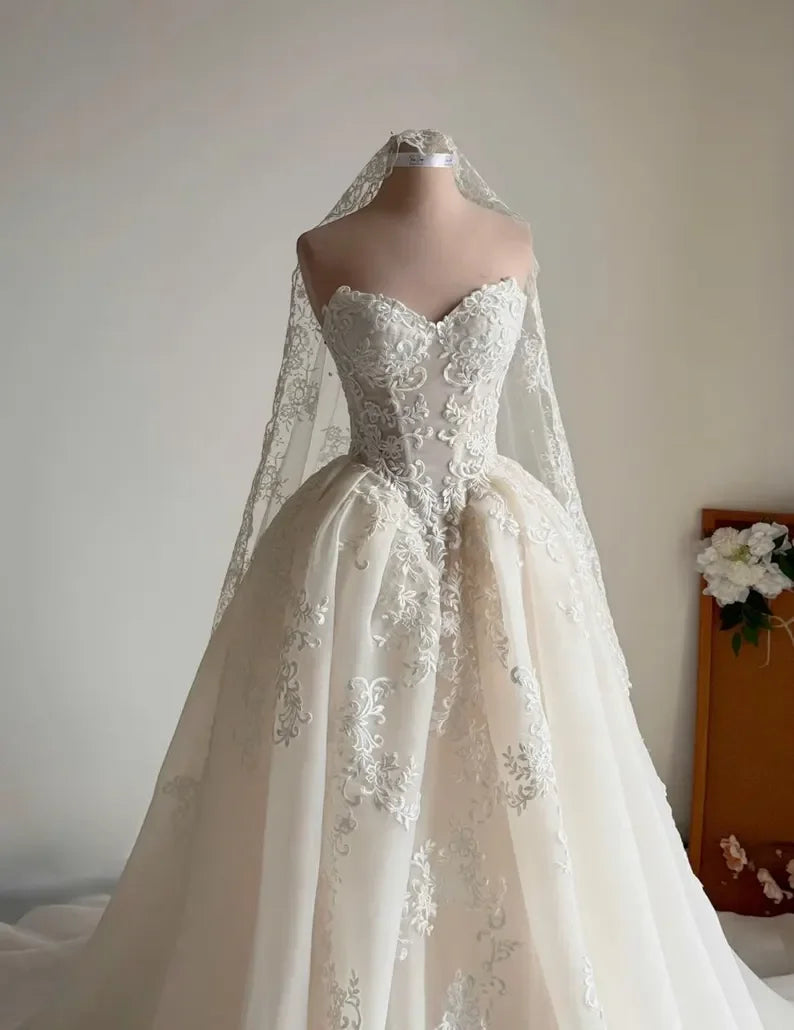 Robe de mariée année 20 de la marque Robe de mariée Paris, détail en dentelle et satin, longueur jusqu'aux chevilles.