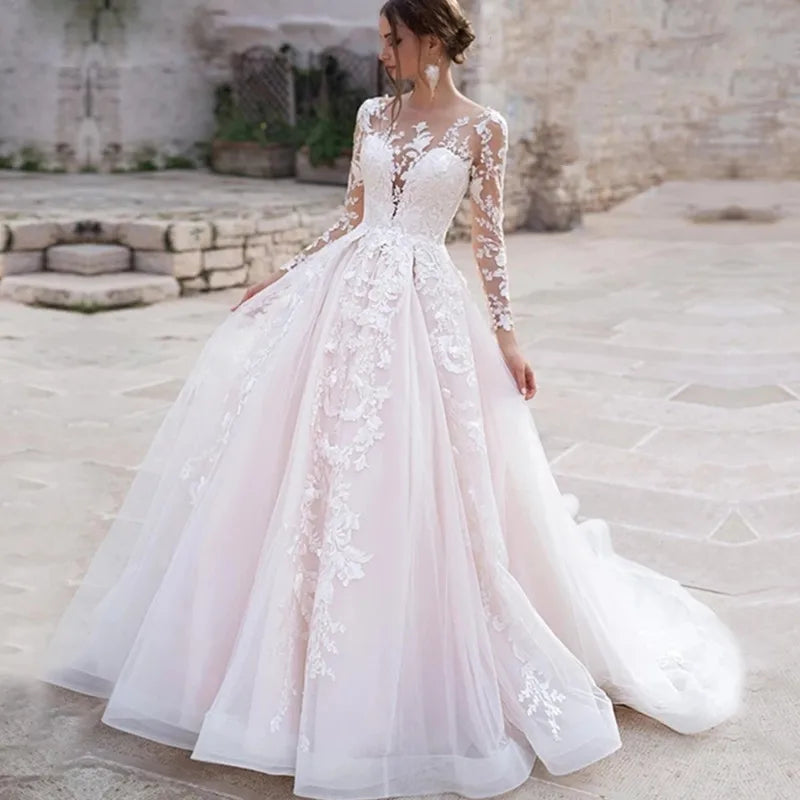 Robe de mariée bohème rose avec dentelle et détails floraux, parfaite pour un mariage romantique et élégant.