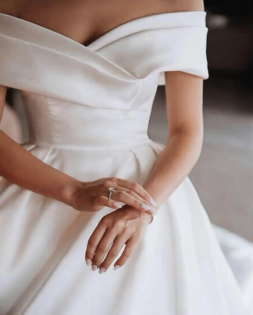 Robe de mariée élégante de Robe de mariée Paris avec dentelle blanche et décolleté en V, vue de face.