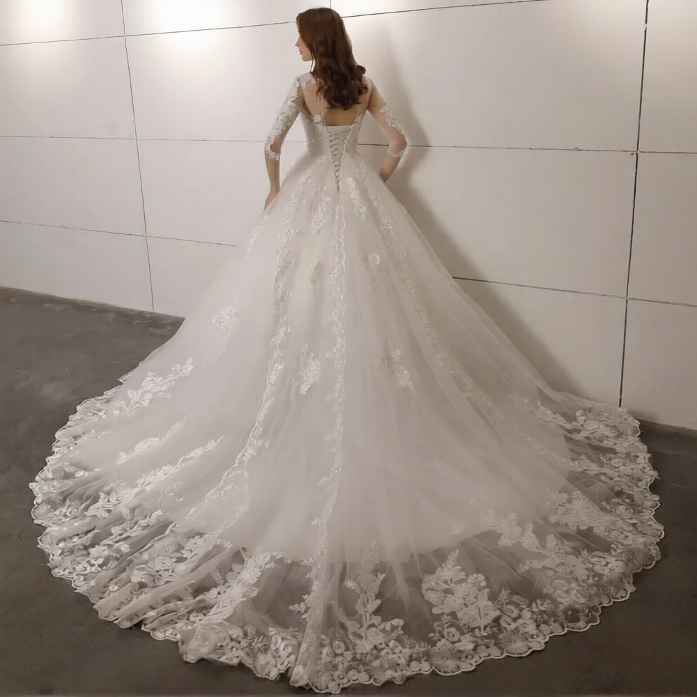 Robe de mariée hiver manches longues de Robe de mariée Paris, élégante avec détails en dentelle et tissu chaud, portée par une modèle.