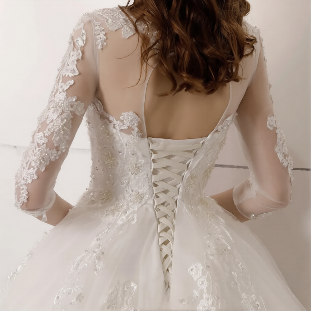Robe de mariée hiver avec manches longues de la marque Robe de mariée Paris, détail élégant et tissu sophistiqué.