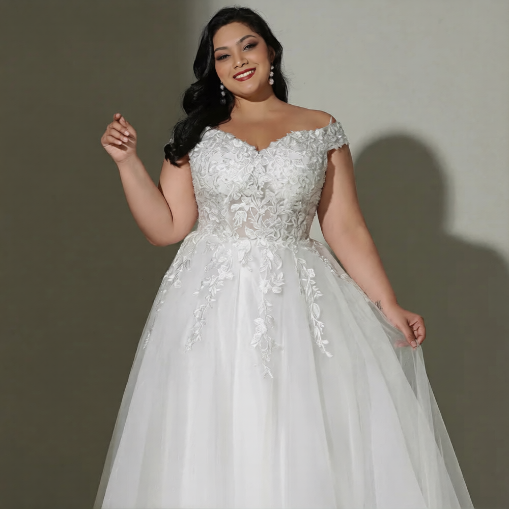 Robe de mariée curve de la marque Robe de mariée Paris, avec dentelle élégante, décolleté en V et jupe fluide.