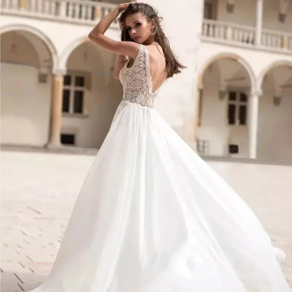 Robe de mariée bohème de plage en tissu léger avec détails floraux, portée par une mannequin en environnement naturel.