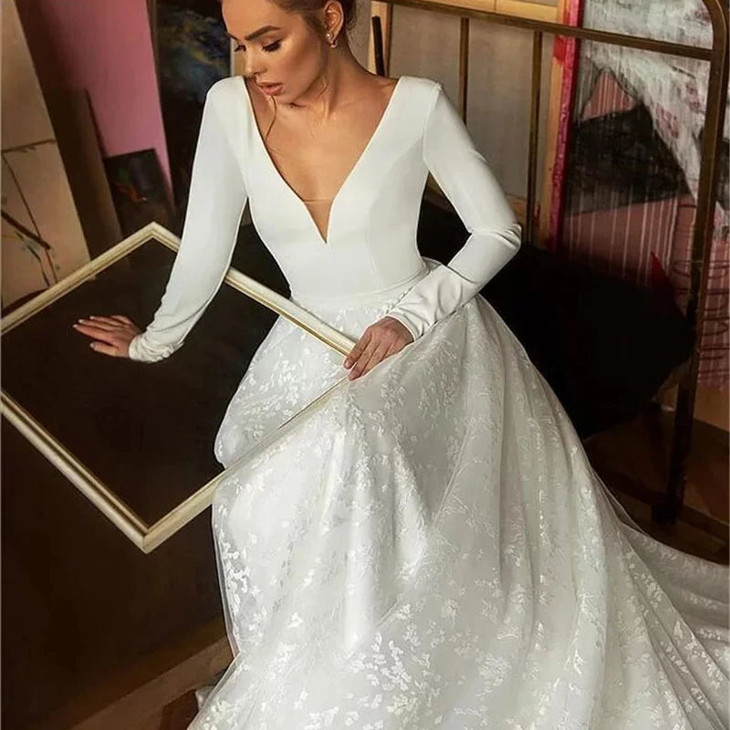 Robe de mariée bohème pour grossesse en dentelle blanche avec décolleté en V et manches longues, élégant style bohème.