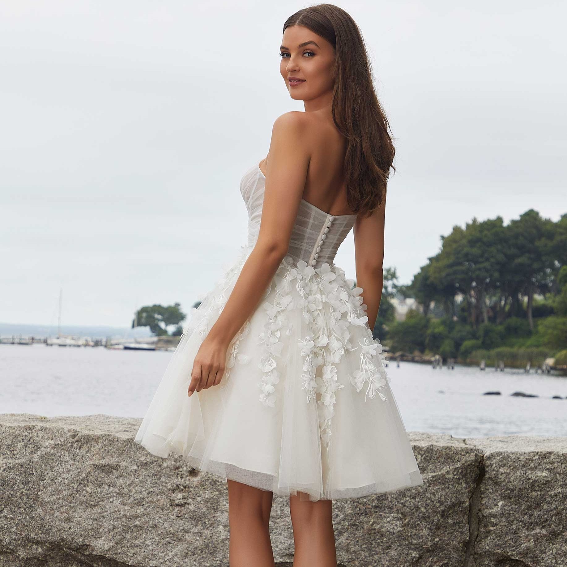 Robe de mariée bohème courte blanche avec détails délicats, style simple et élégant, portée par Naomi, vue de face.