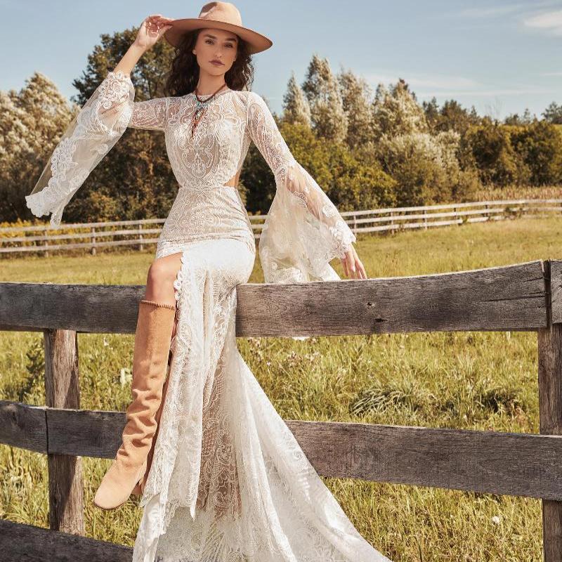 Robe de mariée bohème hippie avec dentelle et détails floraux, portée par la mannequin dans une ambiance romantique.