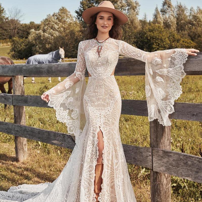 Robe de mariée bohème hippie avec dentelle délicate et jupe fluide, portée par une modèle dans un cadre romantique.