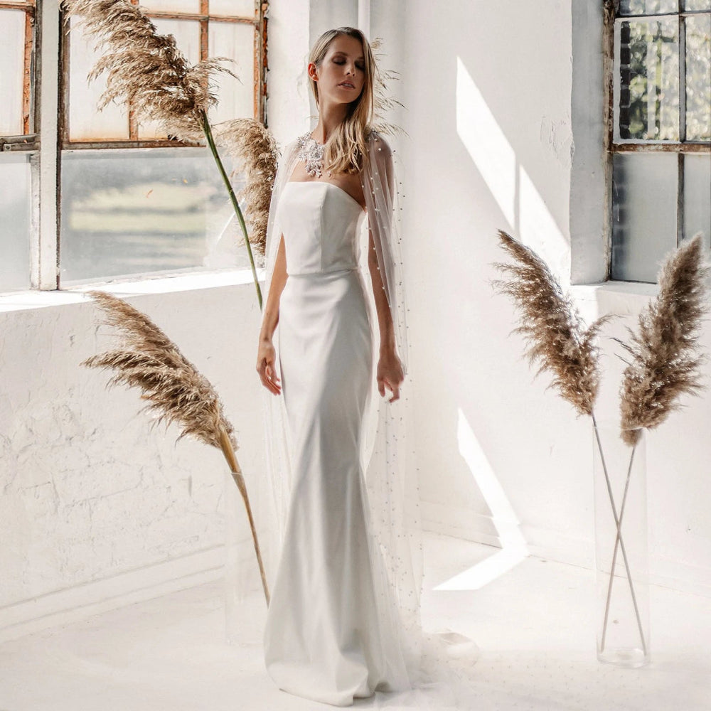 Robe de mariée bohème avec cape en tissu léger, détail élégant et style romantique, vue de face.