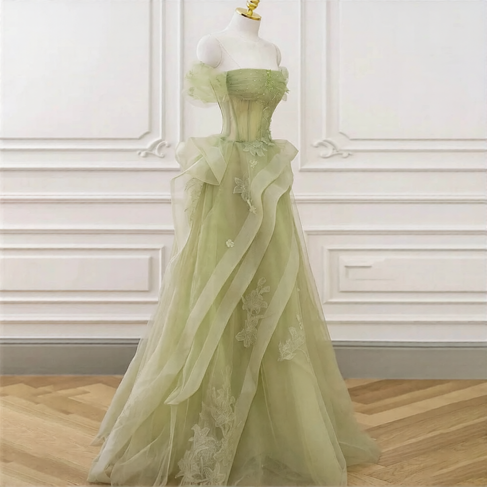 Robe de mariée verte de la marque Robe de Mariée Paris, détail de la robe avec broderies élégantes et tissu fluide.