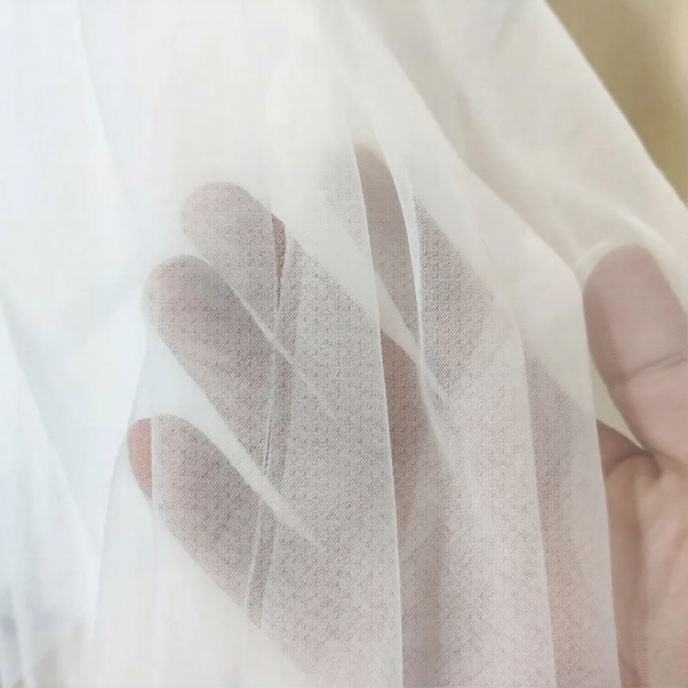 Robe de mariée bohème avec voile en dentelle et tissu fluide, portée par la modèle lors d'une séance photo nuptiale.