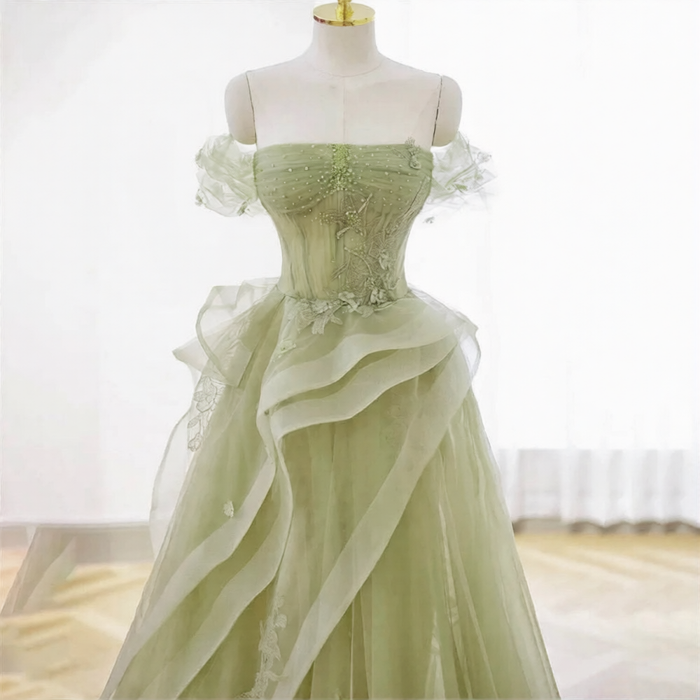 Robe de mariée verte de la marque Robe de Mariée Paris, détail de la robe longue avec broderies et voile élégants.