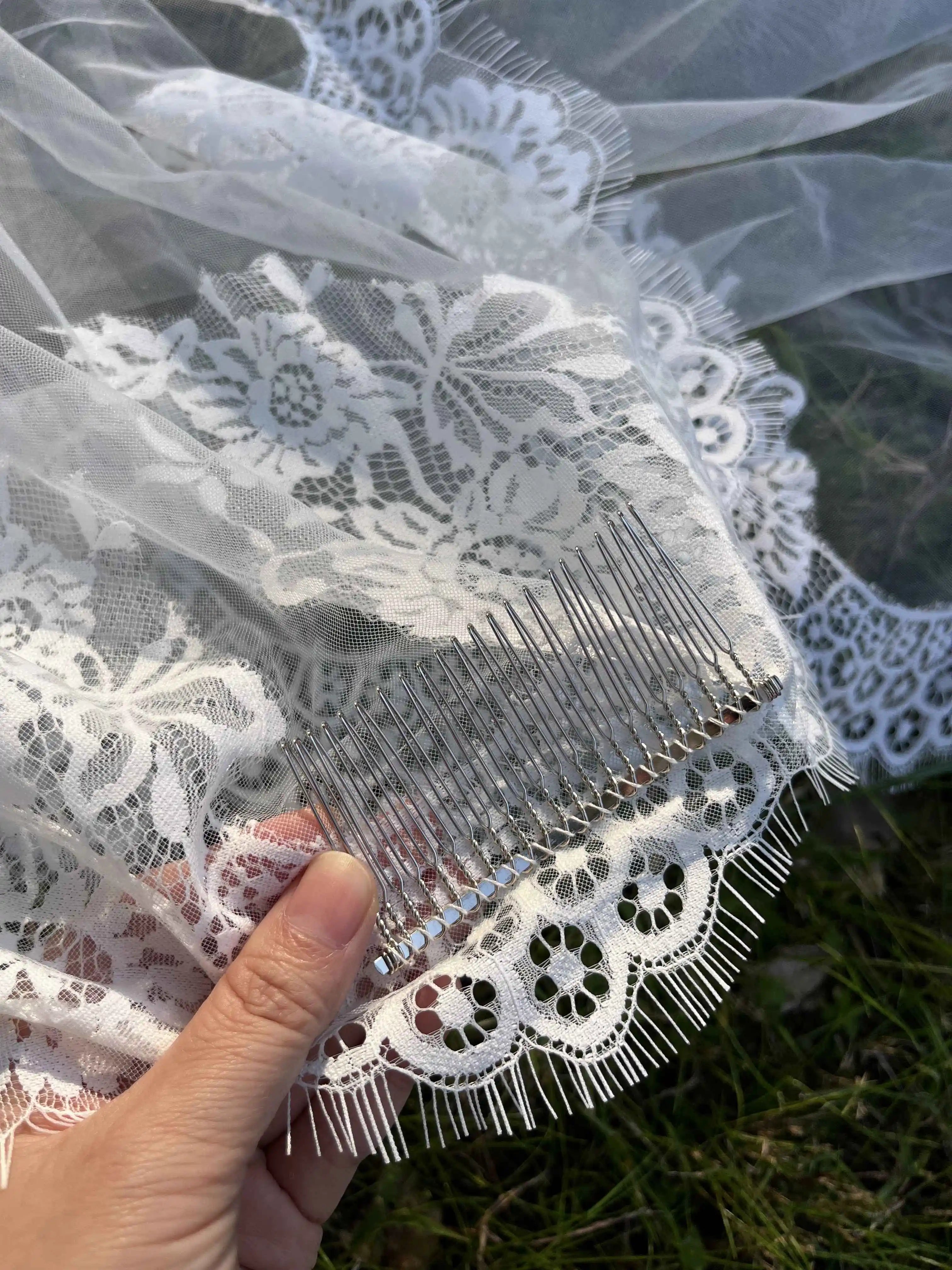 Voile de mariée en dentelle ancienne, robe de mariée bohème avec détails délicats, porté par un modèle en costumes blanc.