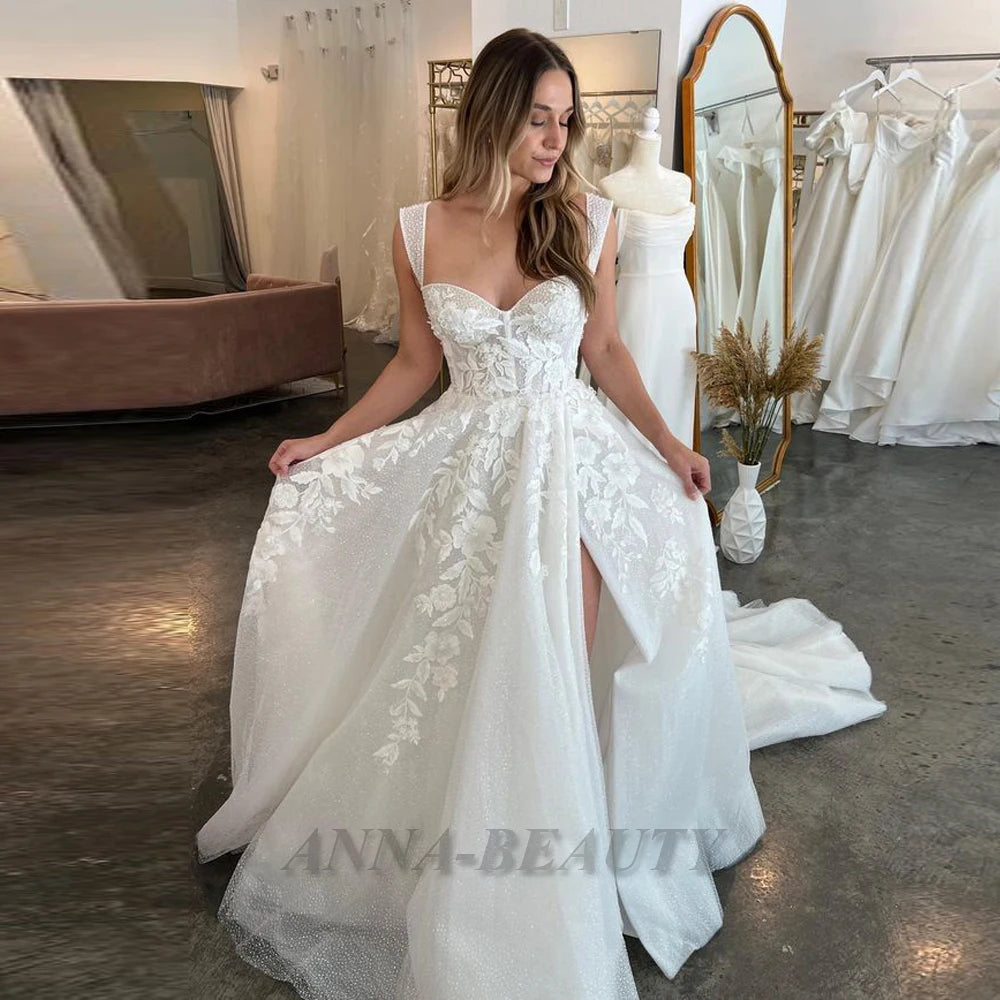 Robe de mariée Anna Charming, robe de mariée en tulle avec décolleté en cœur, jupe évasée, fente haute, train en traîne, détails de lacerie.