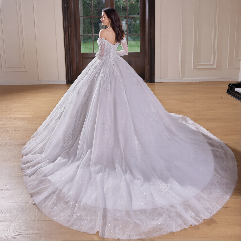 Robe de mariée manches longues Robe de mariée Paris portée sur mannequin avec détails en dentelle et traîne élégante.