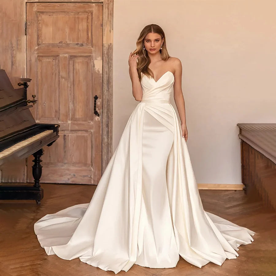 Robe de mariée petite, élégante, avec dentelle blanche, manches longues et ceinture en satin, par Robe de mariée Paris.