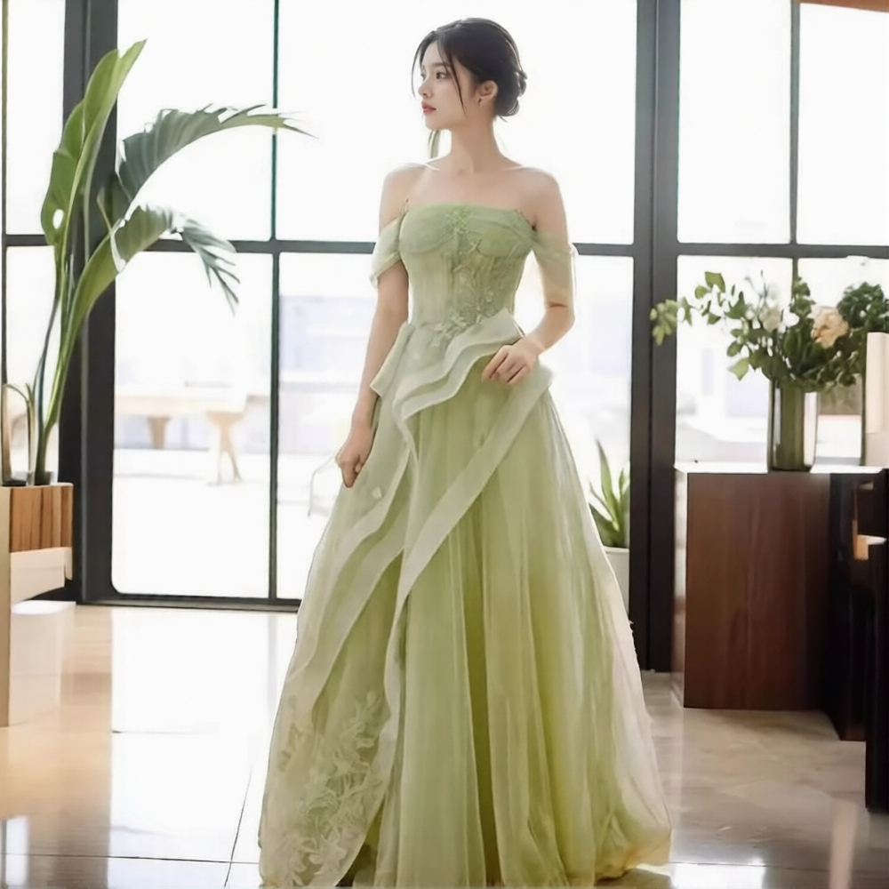 Robe de mariée verte de Robe de mariée Paris, détail de la dentelle et du tissu fluide sur un mannequin.