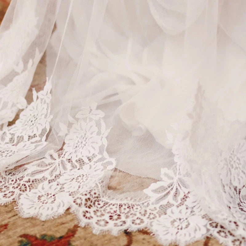 Voile de mariée en dentelle ancienne de la robe de mariée bohème, détails délicats et motifs élégants visibles.