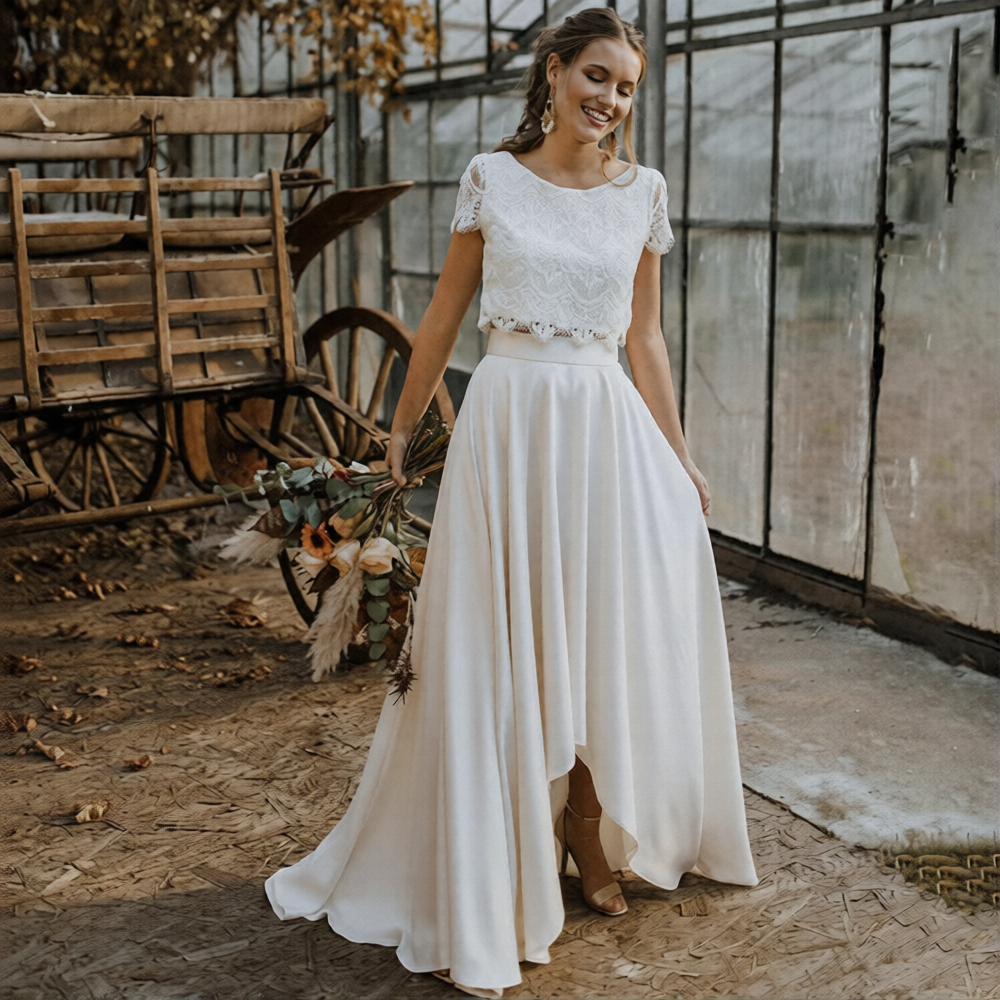 Robe de mariée 2 pièces de la marque Robe de Mariée Paris, avec dentelle et jupe fluide en tissu blanc naturel.