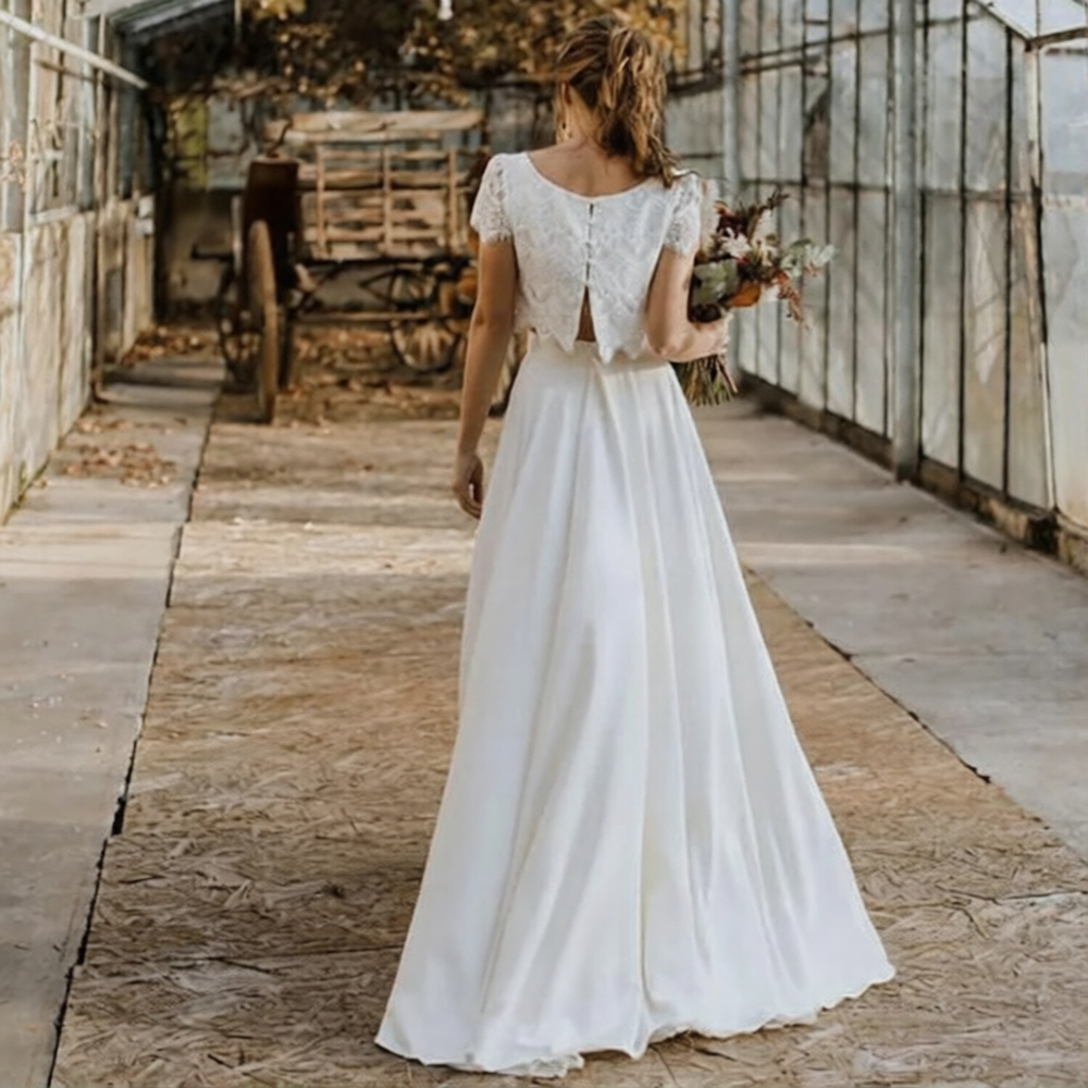 Robe de mariée 2 pièces de Robe de mariée Paris, détail en dentelle avec jupe fluide et haut élégant, vue de face.